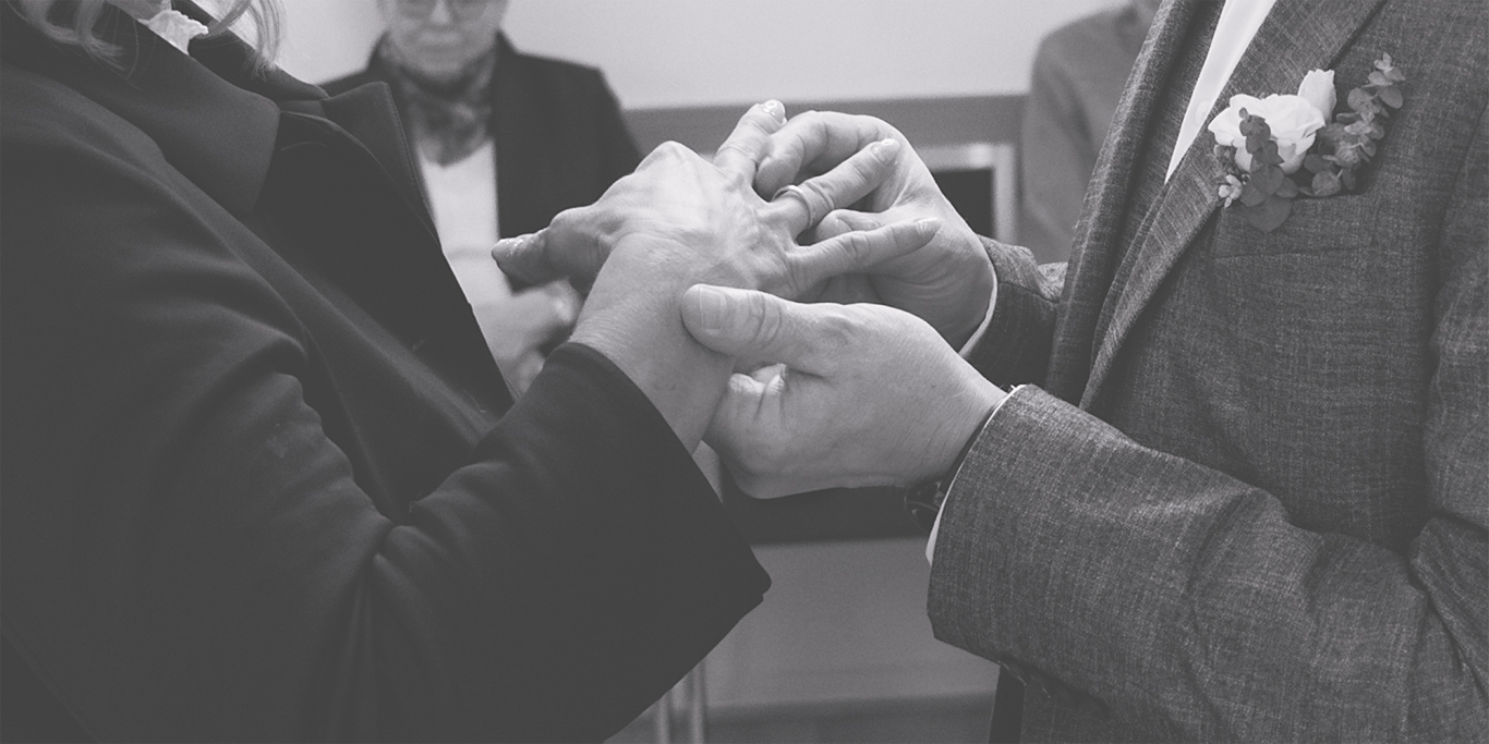 Ringtausch Hochzeit Standesamt Hochzeitszeremonie: zwei Personen tauschen Ringe aus, Hände sind im Fokus.
