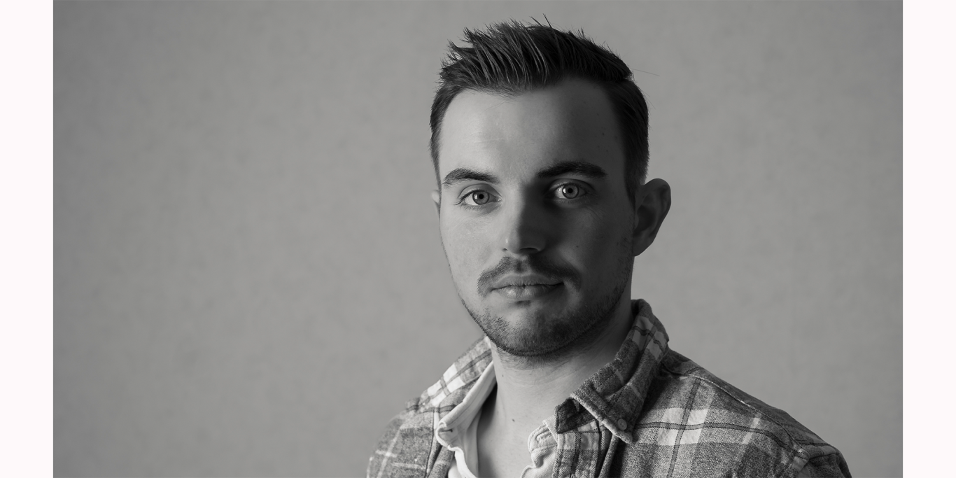 Porträt eines Mannes mit kurz geschnittenen Haaren, in Schwarz-Weiß aufgenommen.