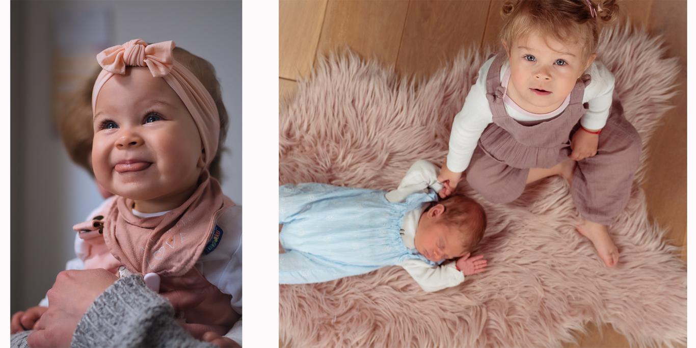 Ein kleines Mädchen lächelt in einanschaubares Outfit, während ein Baby auf einem Teppich liegt.