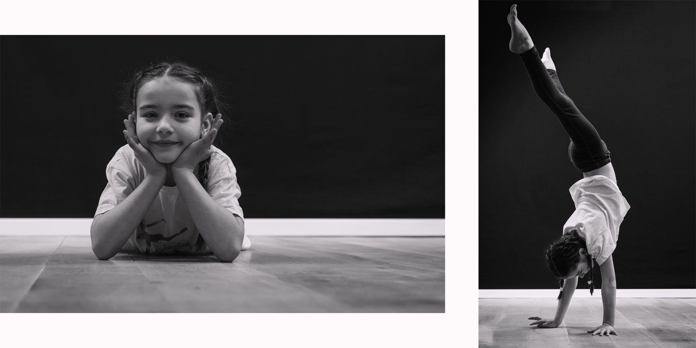 Familienshooting in Kerpen Schwarzweiß Ein Mädchen liegt lächelnd auf dem Boden, daneben ein anderes Mädchen im Handstand.