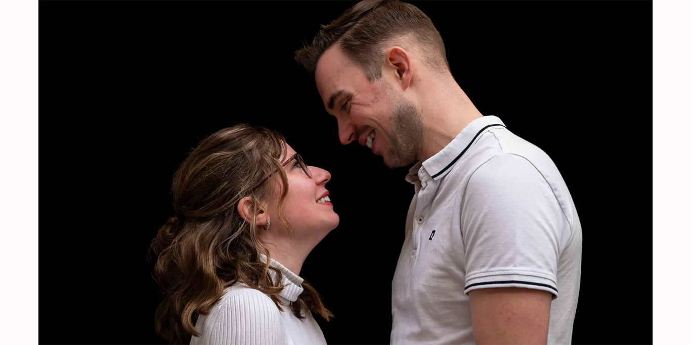 Paarshooting Lächelndes Paar steht sich gegenüber, blickt sich in die Augen.