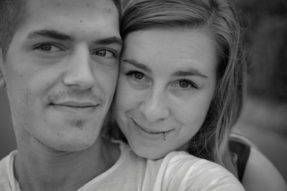 Ein lachendes Paar posiert nahe beieinander mit einem verschwommenen Hintergrund.